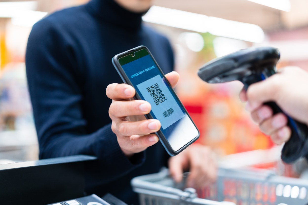 asian man contactless payment with qr code in supermarket