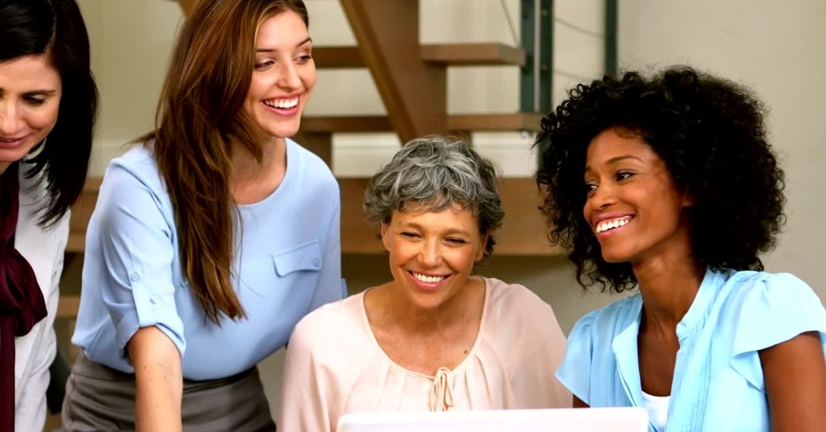 Four women gathered together and smiling