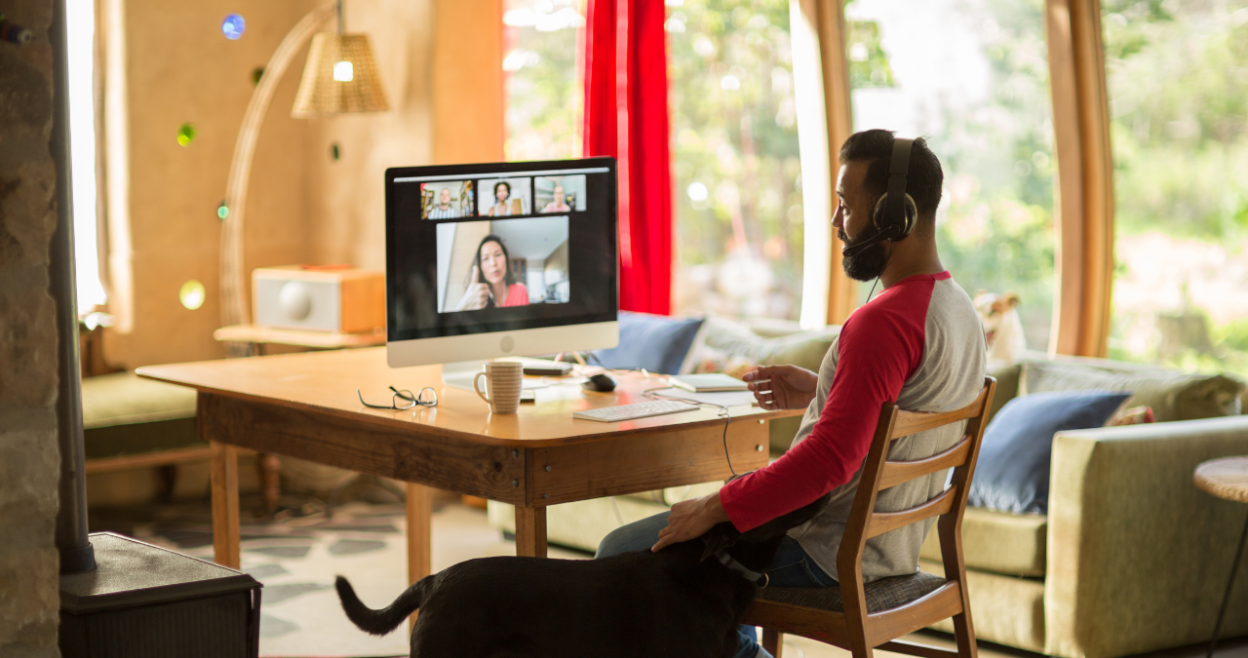 Man petting dog during a video conference call